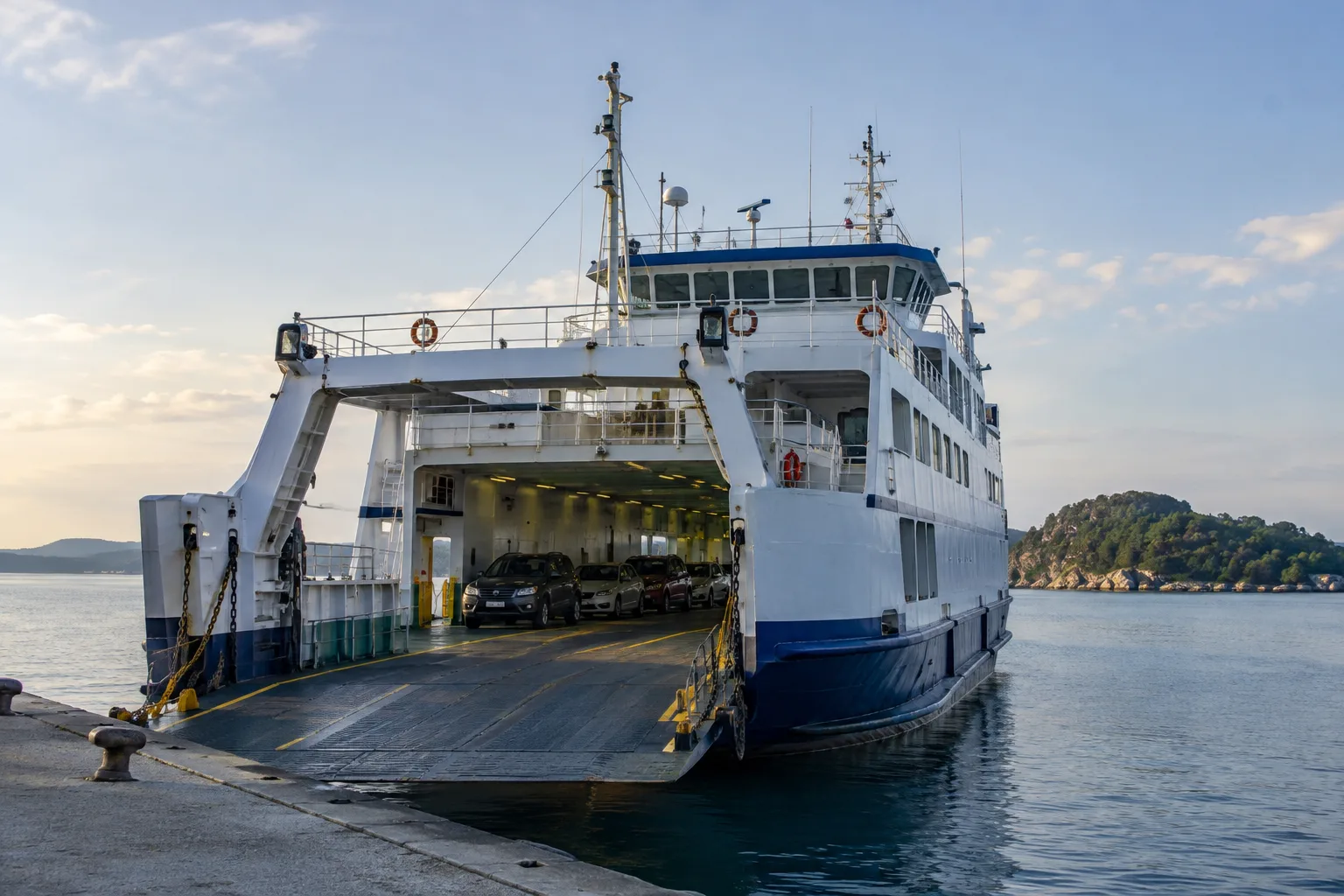 Un ferry prêt à embarquer des voitures dans un port côtier.